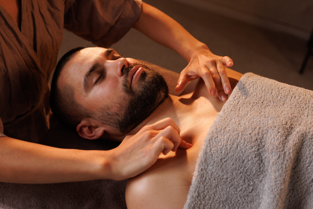 man gets chest massage in spa, enjoying relaxing atmosphere, recovering from work